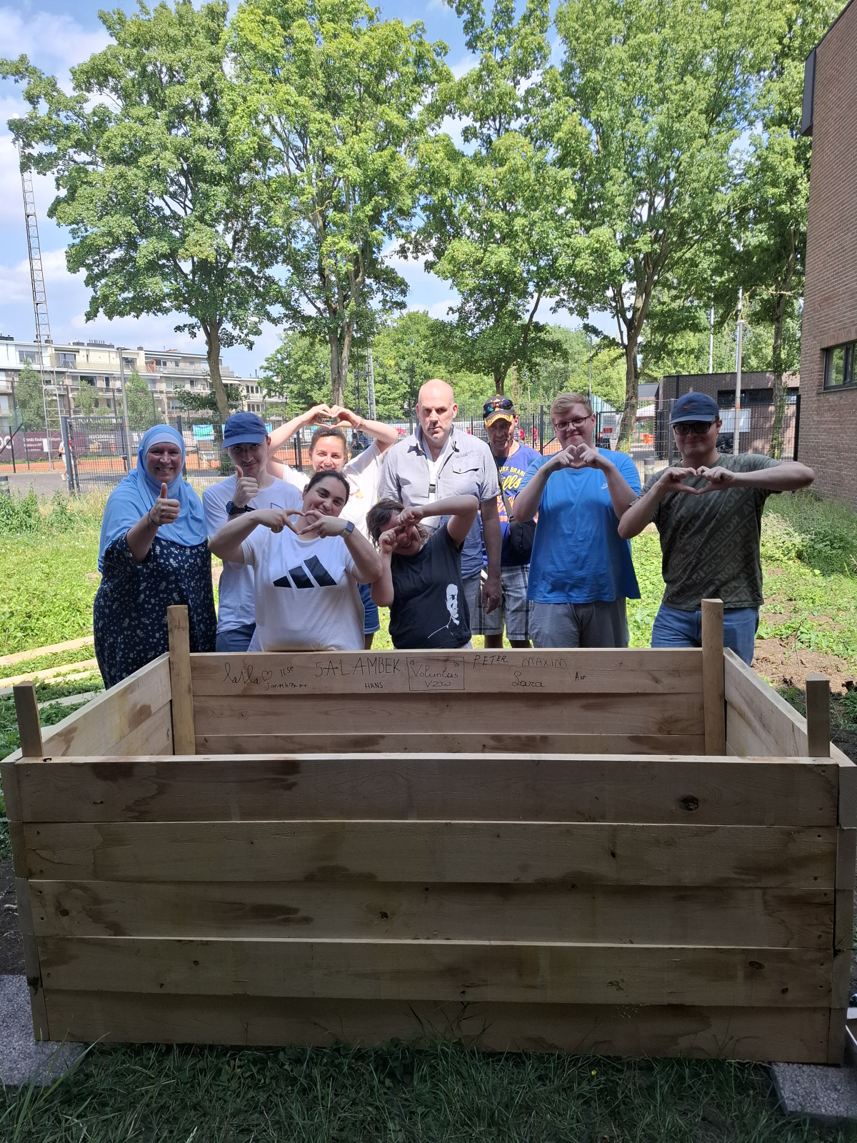 Leden van Voluntas poseren bij een afgemaakte plantenbak